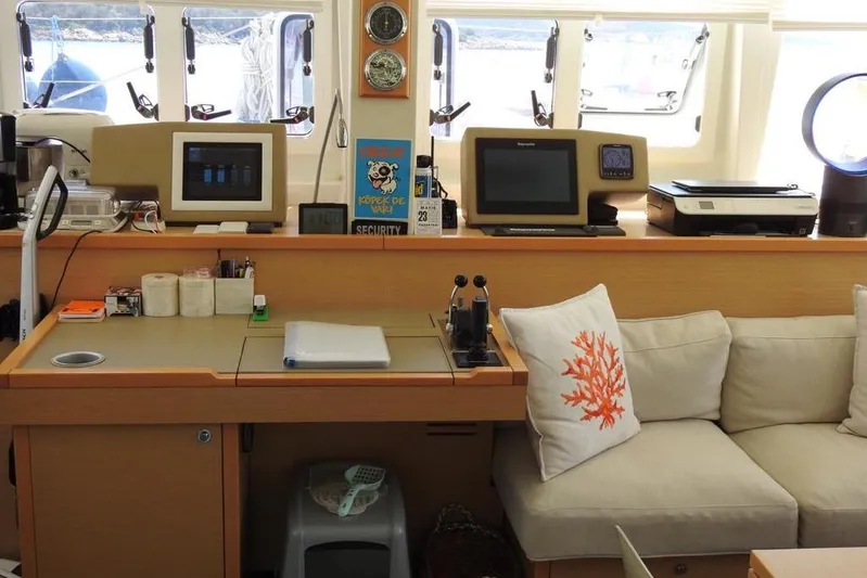  Yacht Photos Pics Interior of 2014 Lagoon 560 S2 yacht with navigation equipment and cozy seating area.