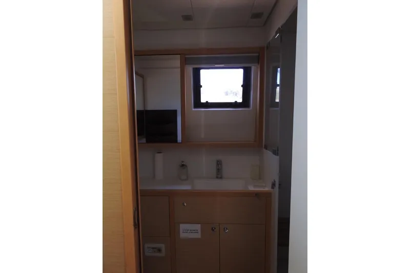  Yacht Photos Pics Bathroom interior of 2014 Lagoon 560 S2 yacht with wooden cabinetry and window.