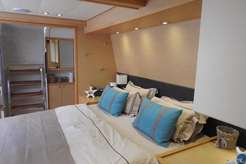  Yacht Photos Pics Luxurious bedroom interior of 2014 Lagoon 560 S2 yacht with modern decor and blue accents.