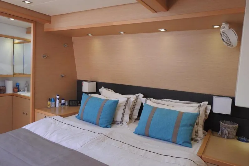  Yacht Photos Pics Luxurious bedroom interior of 2014 Lagoon 560 S2 yacht with modern decor and blue accents.