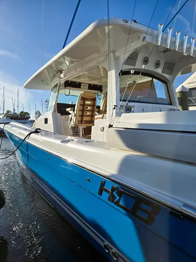 Hcb Yacht Photos Pics 2023 HCB Suenos boat with blue hull docked in marina under clear sky.