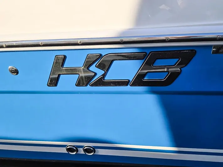 Hcb Yacht Photos Pics HCB Suenos 2023 boat logo on blue hull with chrome accents.