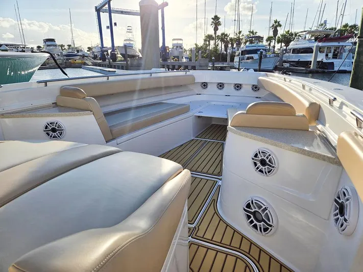 Hcb Yacht Photos Pics 2023 HCB Suenos boat interior with beige seating, wood flooring, and marina background.