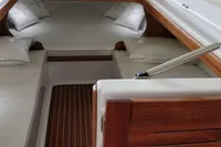 2023 Gozzo Positano 27 Open cabin interior with wooden accents and cozy bedding.