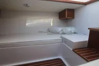 2023 Gozzo Positano 27 Open cabin interior with wooden accents and cushions.
