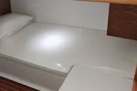 Interior cabin of 2023 Gozzo Positano 27 Open with wooden accents and white bedding.