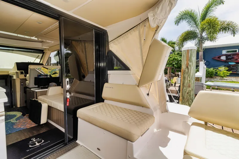  Yacht Photos Pics 2020 Regal 38 XO yacht interior with seating, glass door, and tropical backdrop.