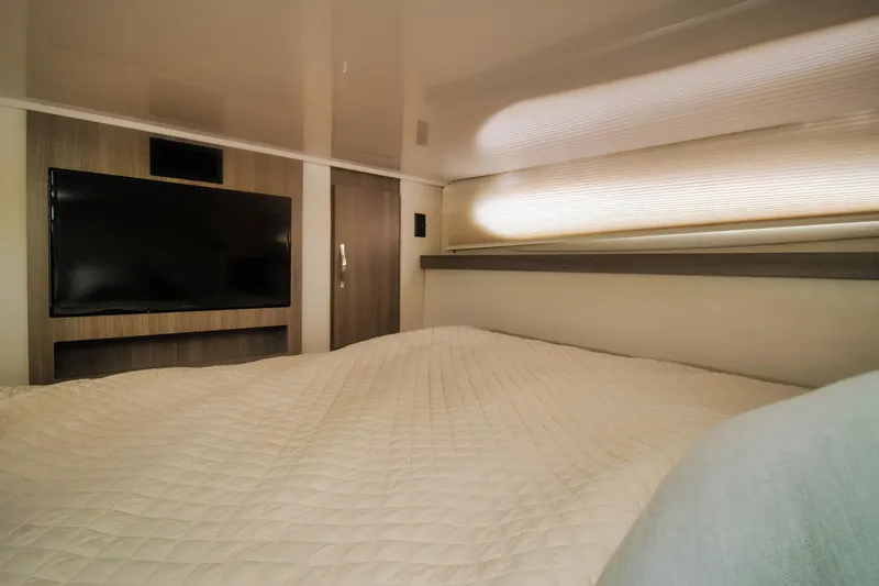  Yacht Photos Pics Luxurious interior cabin of 2020 Regal 38 XO yacht with TV and cozy bedding.