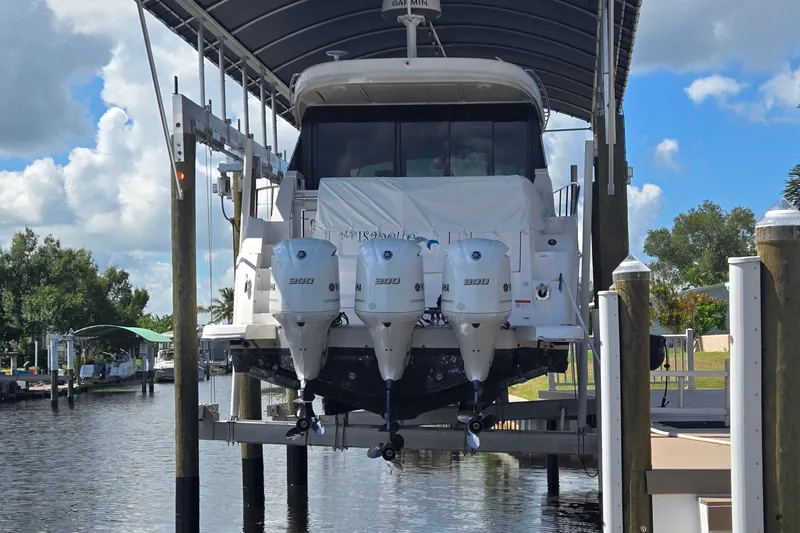  Yacht Photos Pics 2020 Regal 38 XO boat with triple outboard engines on a lift at a marina.