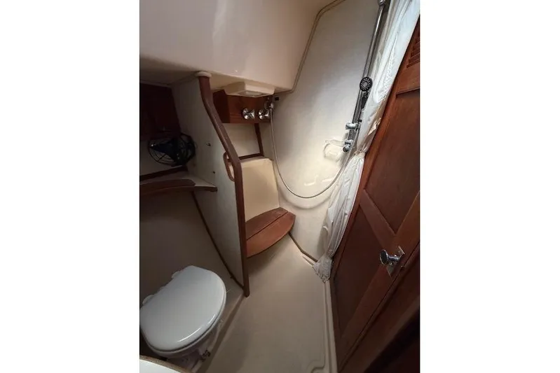 Sugaree Yacht Photos Pics 1997 Island Packet 37 yacht bathroom with shower, toilet, and wooden accents.