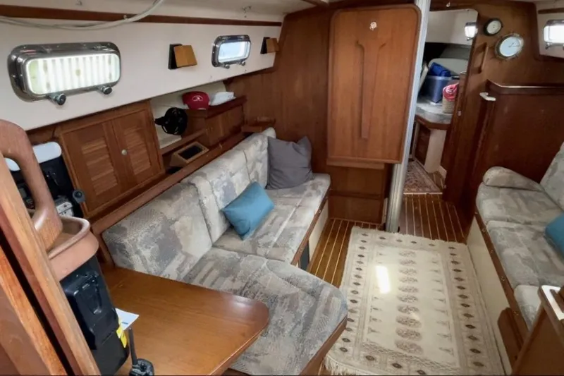 Sugaree Yacht Photos Pics Interior of a 1997 Island Packet 37 sailboat with cozy seating and wooden accents.