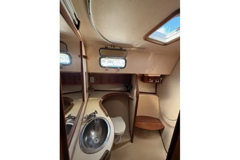 Sugaree Yacht Photos Pics 1997 Island Packet 37 yacht bathroom with sink, toilet, and wooden accents.