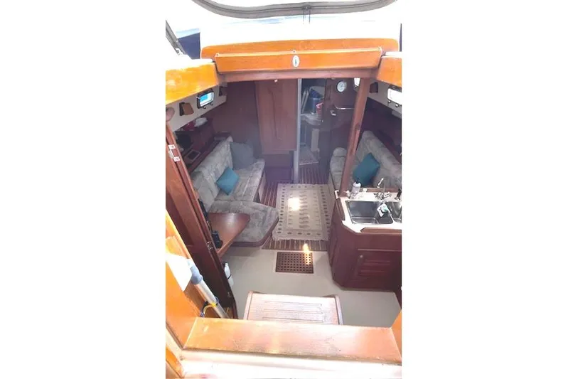 Sugaree Yacht Photos Pics Interior of 1997 Island Packet 37 sailboat, featuring cozy seating and wooden finishes.