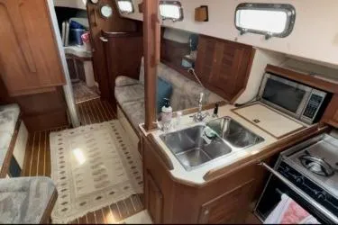Sugaree Yacht Photos Pics Interior of a 1997 Island Packet 37 sailboat with kitchen and seating area.