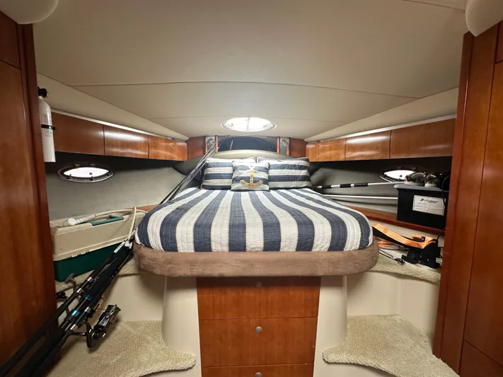 No Dploma Yacht Photos Pics Interior cabin of 2009 Cruisers Yachts 420 Express with striped bedding and wooden cabinetry.