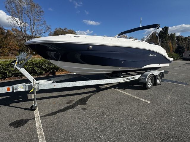 2023 Hurricane SunDeck Sport 205 OB boat on trailer in parking lot.