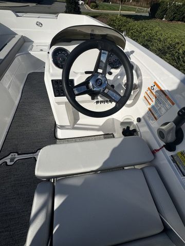 2023 Hurricane SunDeck Sport 205 OB boat interior with steering wheel and seating.