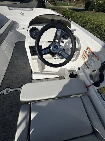 2023 Hurricane SunDeck Sport 205 OB boat interior with steering wheel and seating.