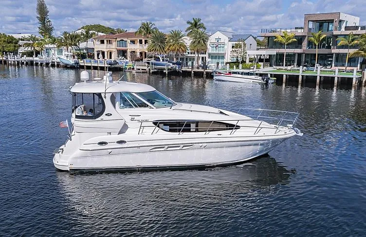 Pure Drive Yacht Photos Pics 2005 Sea Ray 390 Motor Yacht cruising on a scenic waterfront with luxury homes.