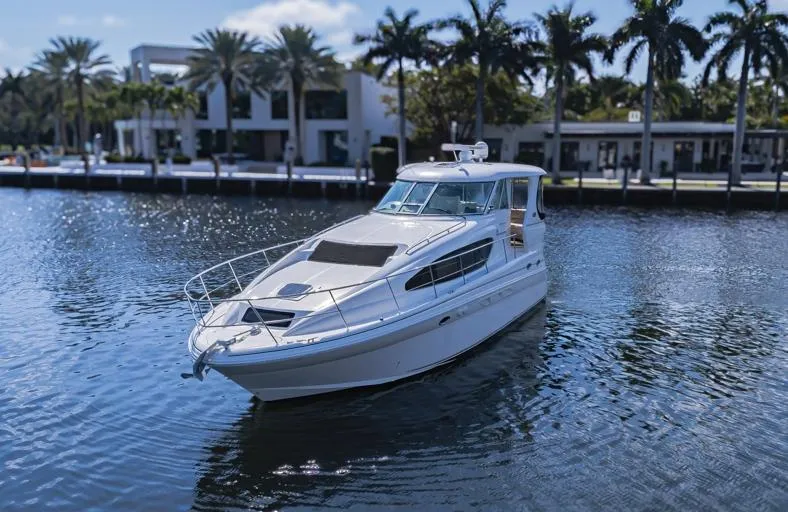 Pure Drive Yacht Photos Pics 2005 Sea Ray 390 Motor Yacht on a serene waterway with palm trees in the background.