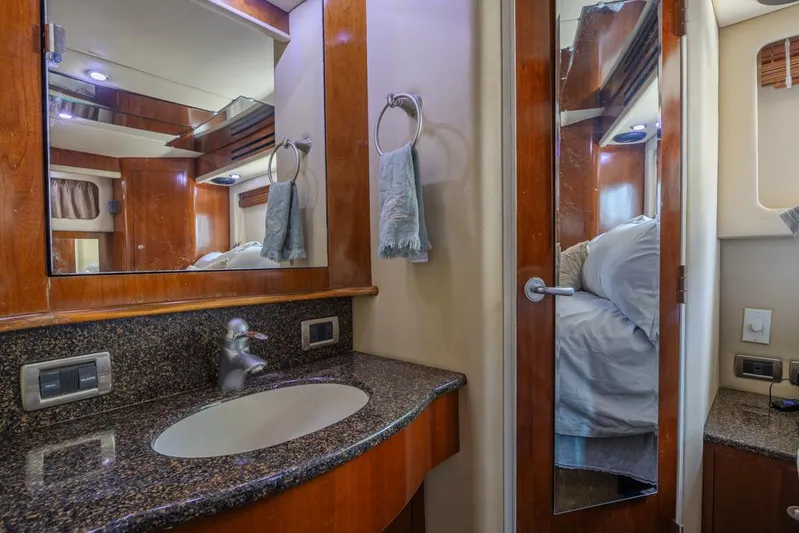 Pure Drive Yacht Photos Pics 2005 Sea Ray 390 Motor Yacht bathroom with granite countertop and wooden cabinetry.