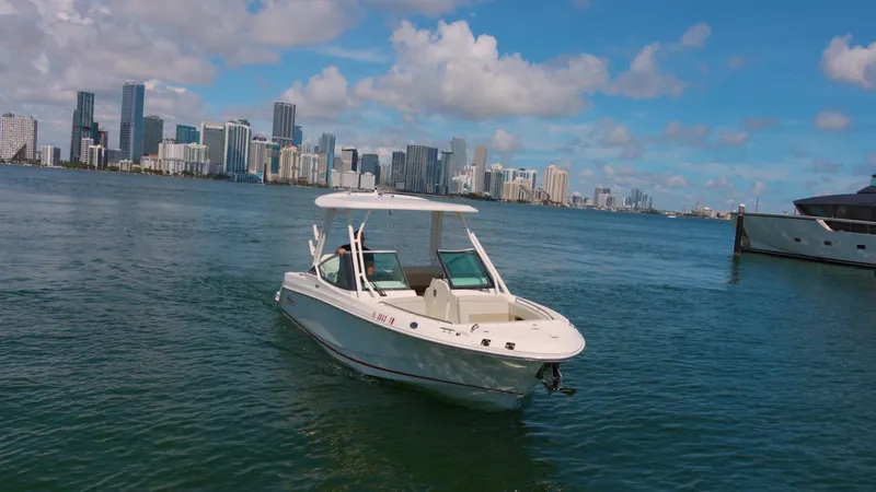  Yacht Photos Pics 2023 Boston Whaler 240 Vantage boat on water with city skyline in background.