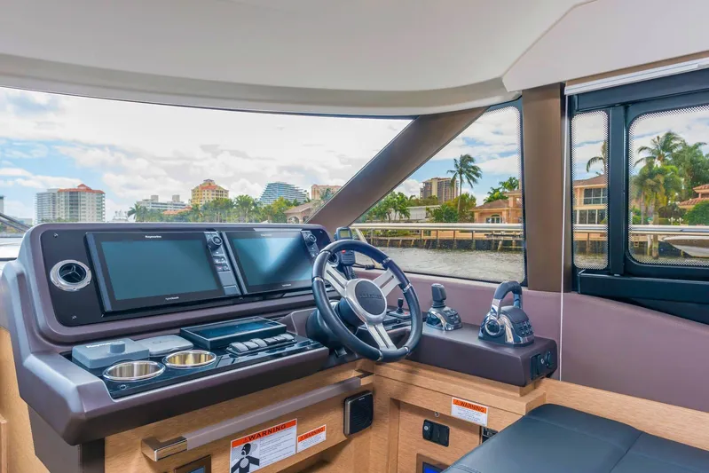  Yacht Photos Pics Interior helm of 2020 Prestige 460 yacht with modern navigation equipment and waterfront view.