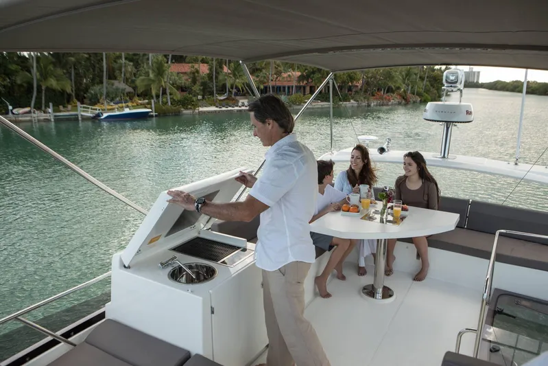  Yacht Photos Pics Family enjoying a meal on a 2020 Prestige 460 yacht, surrounded by scenic water views.