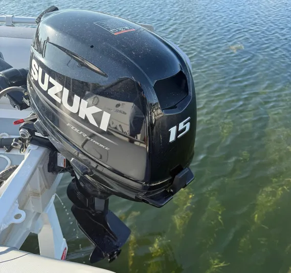 Ciel Rouge Yacht Photos Pics Outboard motor on 2006 Cruisers Yachts 420 Express, Suzuki 15 horsepower, on calm water.