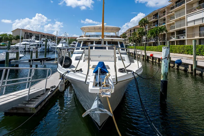  Yacht Photos Pics 2000 Offshore Yachts 58 Pilot House docked at marina under blue sky.