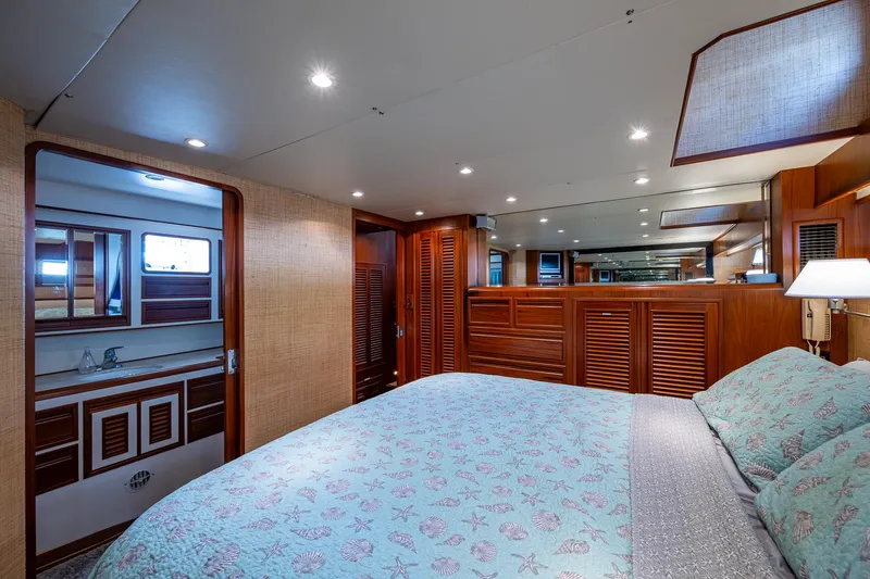  Yacht Photos Pics Luxurious bedroom interior of 2000 Offshore Yachts 58 Pilot House with elegant wood finishes.