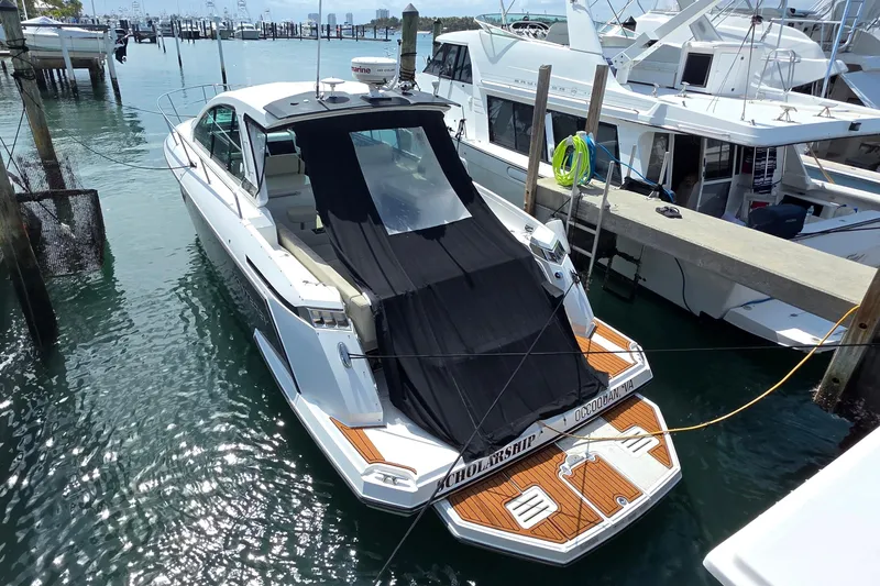  Yacht Photos Pics 2017 Monterey 360 Sport Coupe docked at marina, covered with black tarp.