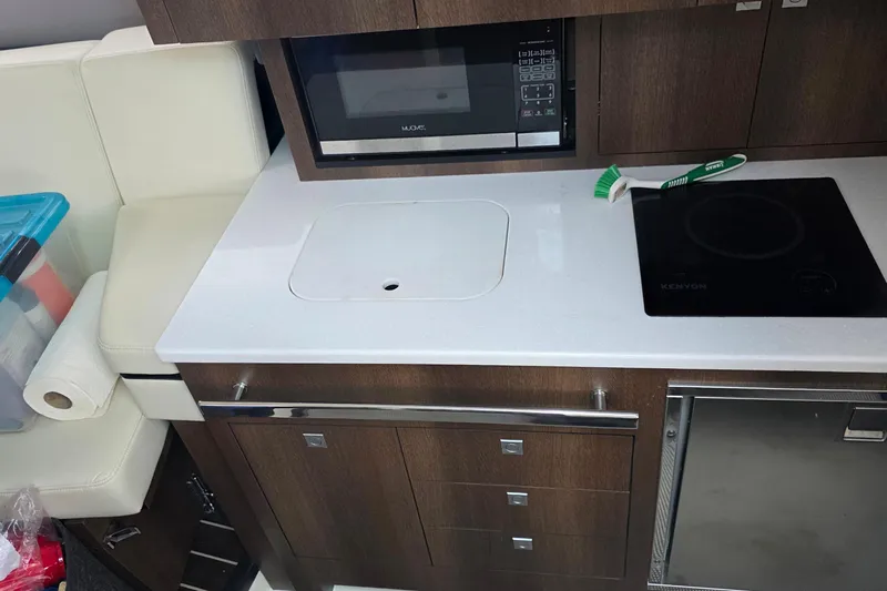  Yacht Photos Pics Compact kitchen area in a 2017 Monterey 360 Sport Coupe with modern appliances.