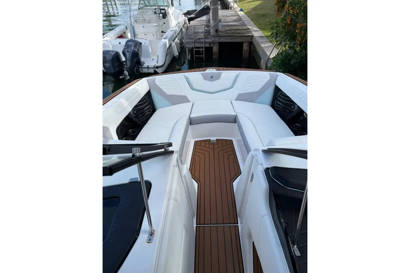  Yacht Photos Pics 2022 Nautique Super Air Nautique G23 Coastal Edition interior with white seating and wooden flooring.