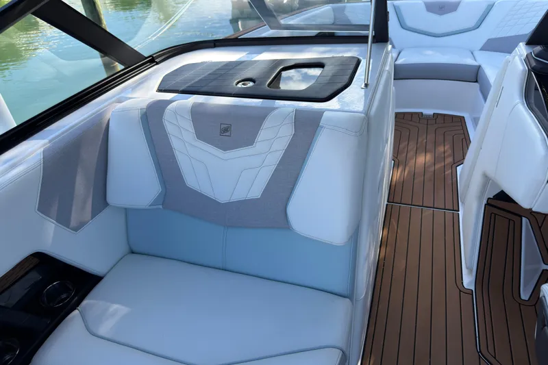  Yacht Photos Pics 2022 Nautique Super Air Nautique G23 Coastal Edition interior with luxurious seating and teak flooring.