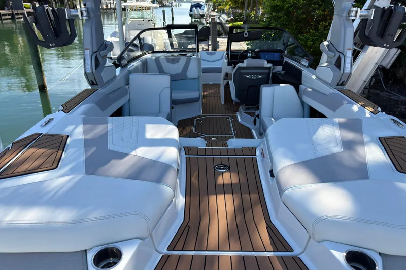  Yacht Photos Pics 2022 Nautique Super Air Nautique G23 Coastal Edition interior with luxurious seating and teak flooring.