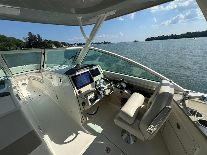  Yacht Photos Pics 2023 Boston Whaler 320 Vantage boat interior with helm, steering wheel, and navigation screens.