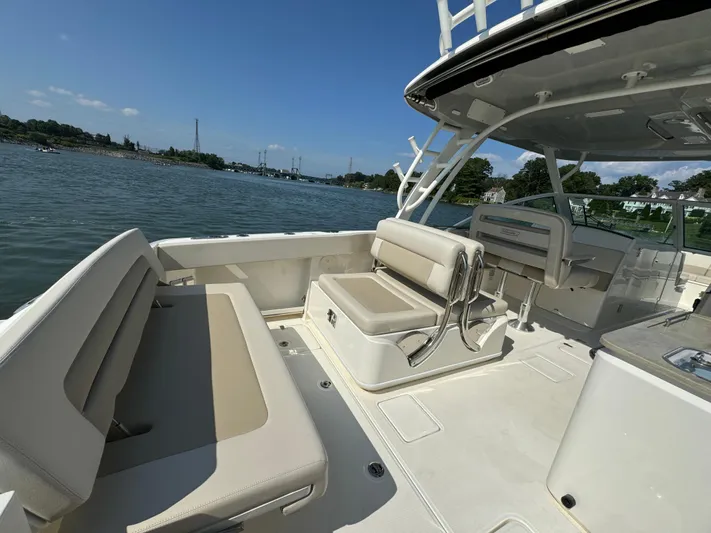  Yacht Photos Pics 2023 Boston Whaler 320 Vantage boat interior with seating, on a sunny day by the water.