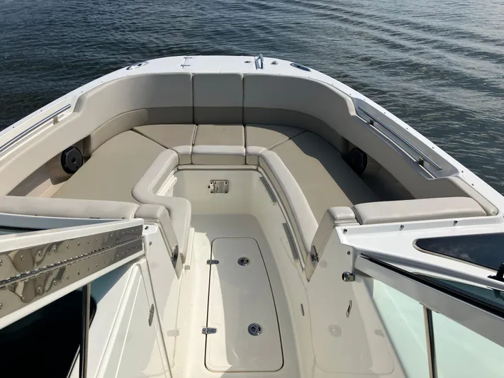  Yacht Photos Pics 2023 Boston Whaler 320 Vantage boat interior with cushioned seating, on calm water.