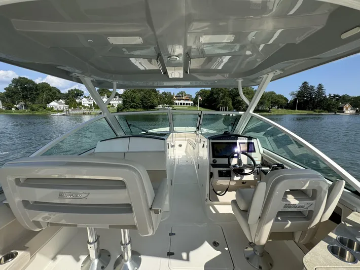  Yacht Photos Pics 2023 Boston Whaler 320 Vantage boat interior with helm and seating on a scenic lake.