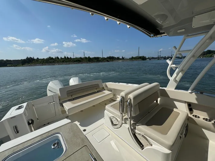  Yacht Photos Pics 2023 Boston Whaler 320 Vantage boat interior with seating, on a sunny day by the water.
