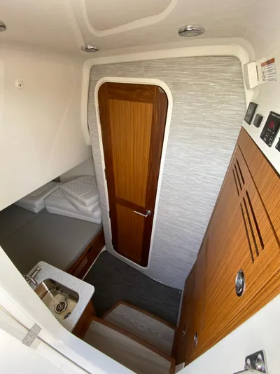  Yacht Photos Pics Interior cabin of 2025 Solace 37 CS boat with wooden door and compact amenities.