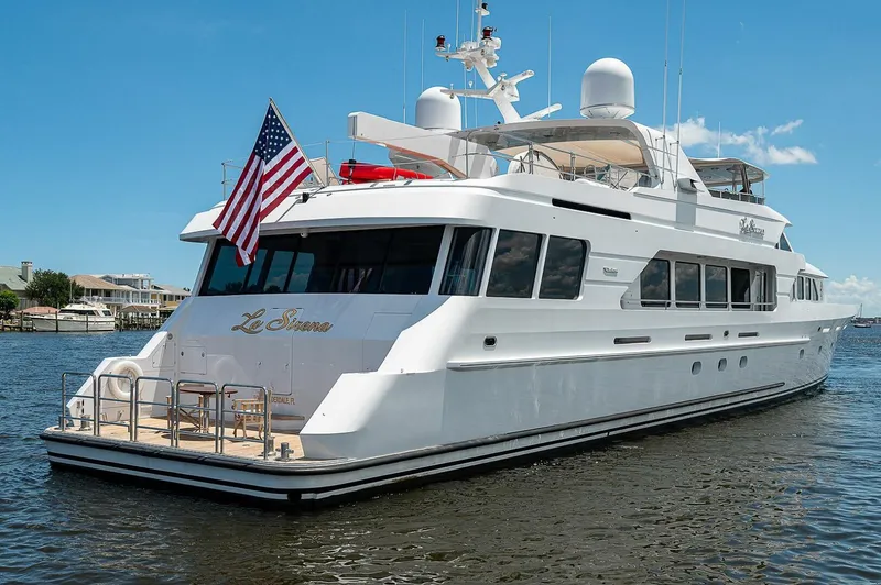La Sirena Yacht Photos Pics Luxury Christensen 141 Raised Pilothouse yacht, 2000 model, with American flag, docked on calm water.