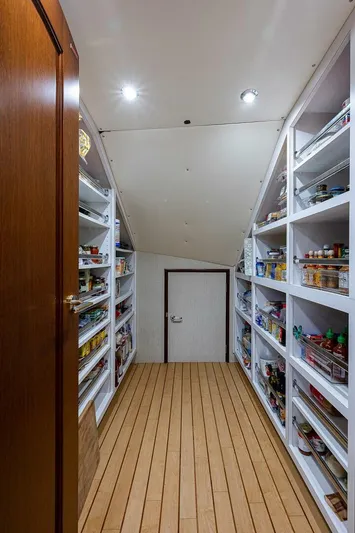 La Sirena Yacht Photos Pics Spacious pantry with wooden flooring and well-organized shelves on a Christensen 141 Raised Pilothouse yacht.