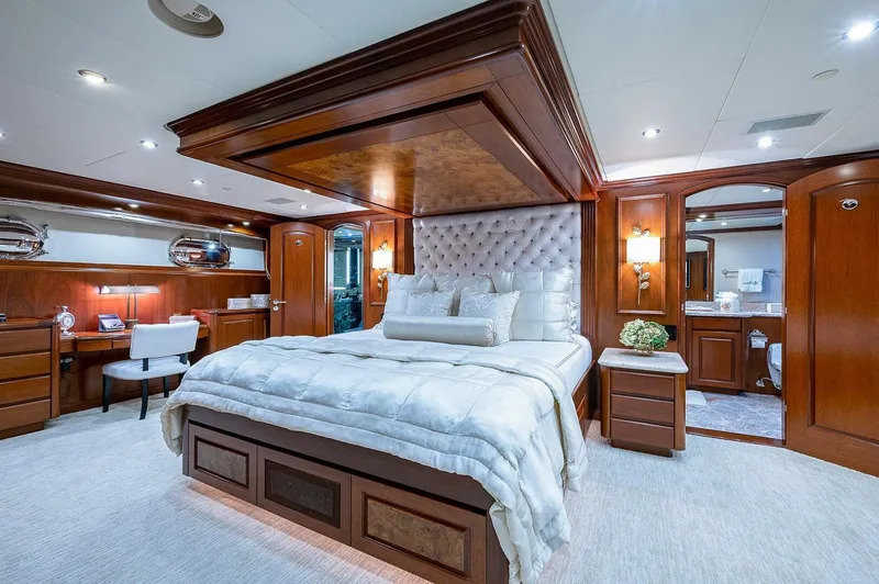 La Sirena Yacht Photos Pics Luxurious bedroom on Christensen 141 Raised Pilothouse yacht, featuring elegant wood paneling and plush bedding.