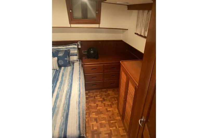 Gb421500 Yacht Photos Pics Cozy cabin interior of 2002 Grand Banks 42 Classic with wood furnishings and striped bedding.