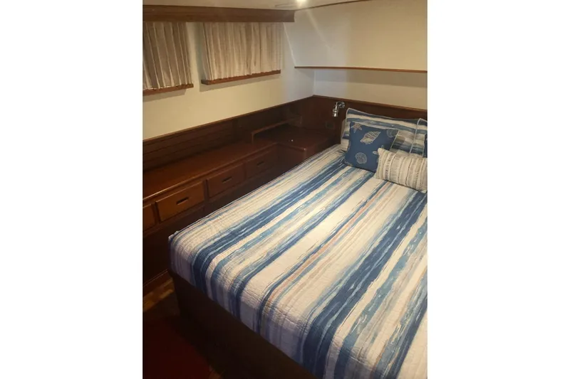 Gb421500 Yacht Photos Pics Cozy cabin interior of 2002 Grand Banks 42 Classic with striped bedding and wooden storage.