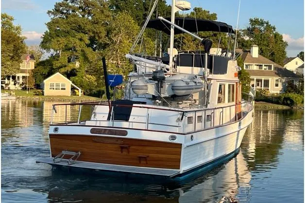 Gb421500 Yacht Photos Pics 2002 Grand Banks 42 Classic yacht on serene water near waterfront homes.