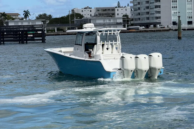  Yacht Photos Pics 2020 Sportsman Open 352 Center Console boat cruising on water near urban buildings.