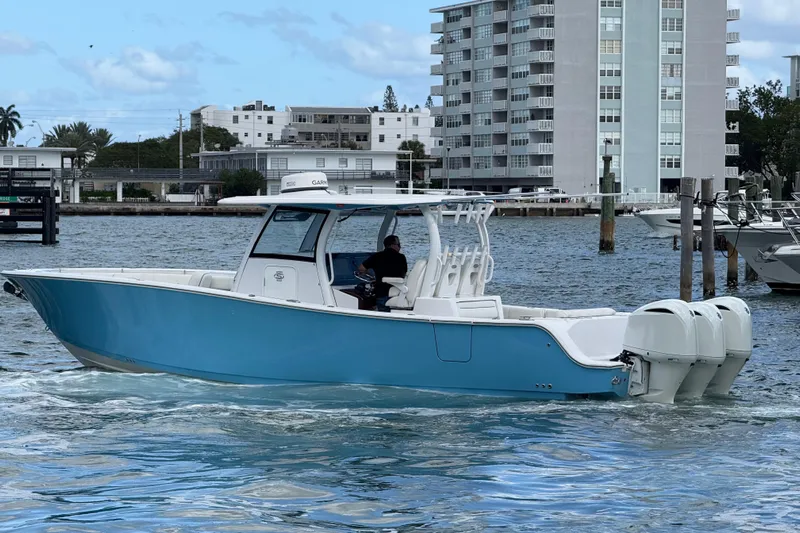  Yacht Photos Pics 2020 Sportsman Open 352 Center Console boat cruising near waterfront buildings.